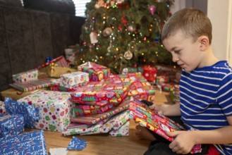 Denver, Colorado - A boy opens Christmas presents on Christmas morning