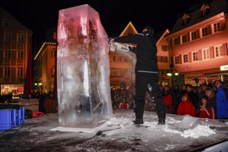 An ice sculpture is being created: ice carving street action as part of the long shopping night in
