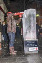 An ice sculpture is being created: ice carving street action as part of the long shopping night in