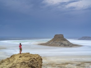A tourist admires the inselbergs Karamaya and the Three Brothers (Three Batyrs), the Karagiye