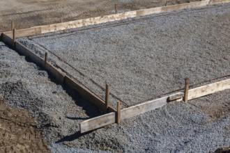 Wooden concrete pouring forms and bed of crushed and compacted stone aggregate to rest concrete