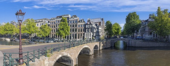 Holland, Amsterdam canals with boats, scenic bridges and historic city center, UNESCO World