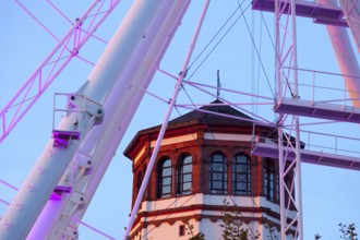 Rhine promenade with illuminated Ferris wheel and castle tower at dusk, Düsseldorf, North