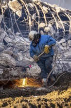 Workers with cutting torches demolishing the 120-meter long motorway bridge of the A516, across