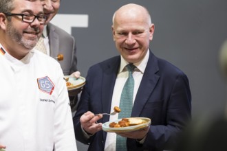 Kai Wegner (Governing Mayor of Berlin) tries a currywurst during the opening tour of the Green Week