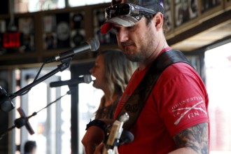 Musicians sing into microphones while playing acoustic guitar, rock atmosphere reigns, Nashville,