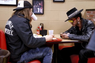 Two people eat and talk at a table in Arnold's Country Kitchen, Nashville, Tennessee, USA