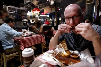 A man enjoys BBQ at Charlie Vegos' Rendezvous Restaurant in Memphis, Memphis, Tennessee, USA
