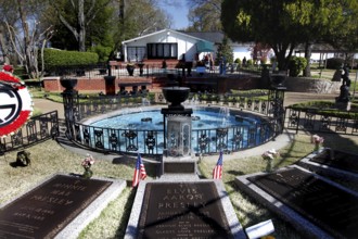 Graves with flags and a round fountain in a green setting, Memphis, Tennessee, USA
