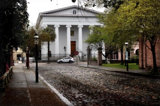 Historic building with pillars on a paved street in Charleston, Charleston, South Carolina, USA