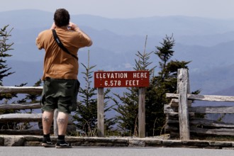 A tourist photographs the landscape at the viewpoint of Mount Mitchell State Park, Mount Mitchell
