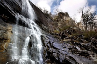 Natural waterfall on steep rocks against a blue sky in Chimney Rock, zero