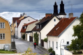 Narrow alley with traditional houses under ominous skies, Visby, Gotland, Sweden