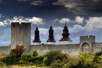 Medieval city wall of Visby with towers and dramatic sky, Visby, Gotland, Sweden