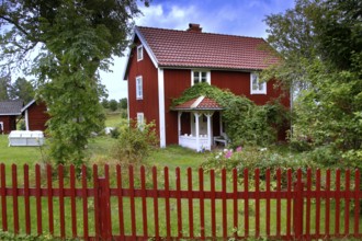 Red house surrounded by trees in an idyllic landscape, Svedstorp, Sweden