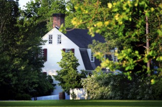 A historic building surrounded by lush trees in Colonial Williamsburg, Williamsburg, Virginia, USA