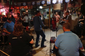 A Cajun band plays in Fred's Lounge with dancers in the background, Mamou, Louisiana, USA