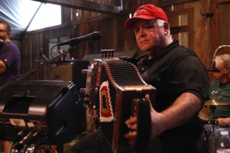 Accordion player on stage in the rustic setting of Randolph's Restaurant, Lafayette, Louisiana, USA