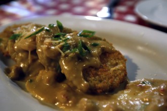 Baked green tomatoes with sauce and herbs served at Prejean's restaurant, Lafayette, Louisiana, USA