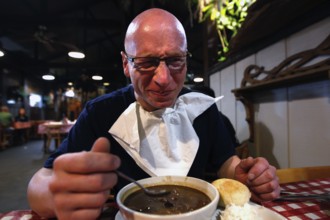 A man enjoying a meal in a rustic restaurant, Lafayette, Louisiana, USA