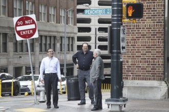 People stand on a street corner in Downtown Atlanta on Peachtree Street, Atlanta, USA