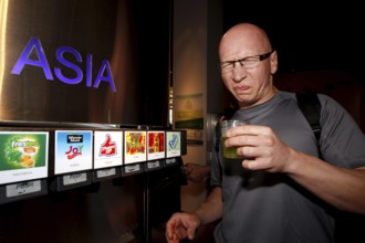 A man in the tasting room of the Coca-Cola Museum in Atlanta tastes Asian drinks with curious