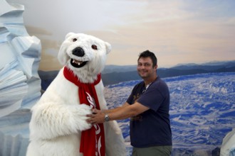 Person posing with Coca-Cola polar bear at the Coca-Cola Museum, cheerful atmosphere, Atlanta,