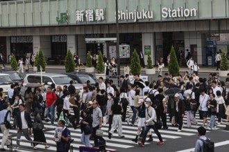 Passers-by cross the street in front of Shinjuku Station in Tokyo, Tokyo, Shinjuku, Japan