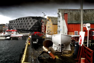 Wooden houses and boats at the stormy harbor of Tromsø, Tromsø, Troms, Norway