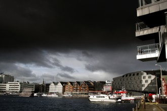 Wooden houses and water in central Tromsø under dark sky, Tromsø, Troms, Norway