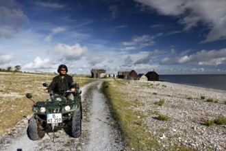Man riding an ATV on a coastal path near Helgumannen, Helgumannen, Fårö, Sweden
