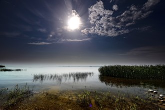 Brilliant full moon over the quiet Curonian Lagoon at night in Vente, Vente, Lithuania