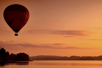 Hot air balloon at dusk over a still lake, Trakai, Vilniaus Apskritis, Lithuania