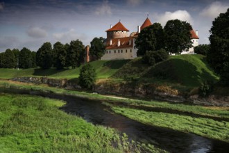 Crusader castle on Musa surrounded by green landscape and clouds in the sky, Bauska, Latvia
