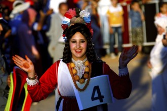 Smiling woman in traditional dress taking part in the Fête des Roses, El Kelâa m'Gouna,