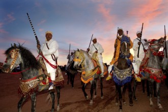 Riders wearing traditional clothes at sunset during a Fantasia performance, El Kelâa m'Gouna,