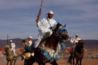 Riders on decorated horses present their skills at Fantasia, El Kelâa m'Gouna, Morocco