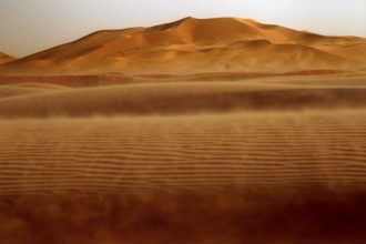 Dust envelops the sand dunes in the sprawling Erg Chebbi, Erg Chebbi, Morocco