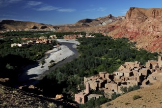 Contrasting landscape with clay buildings, river and mountains in the valley, El Kelâa m'Gouna,