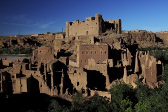 Clay kasbahs in a majestic desert backdrop under clear blue sky, El Kelâa m'Gouna, Valley of Roses,