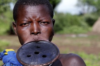 Portrait of a Mursi woman with lip plate and distinctive facial expression in Mago National Park,