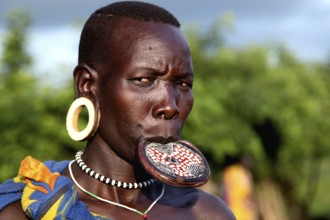 Close-up of a Mursi woman with lip plate in Mago National Park. She is wearing traditional