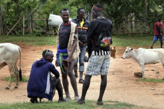 Men stand with cattle at a cattle market in Key Afar