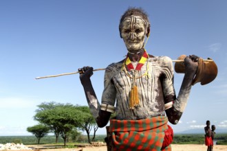 Old man from Murle with traditional checkered painting and antelope head, Murle, Ethiopia