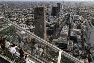 People ride down an escalator in Shibuya Sky with a view of Tokyo, Tokyo, Shibuya, Japan