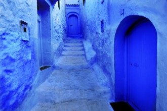 Narrow, blue alleyway section of the medina of Chefchaouen with weathered stairs, Chefchaouen,