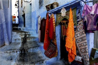 Picturesque blue road in the medina of Chefchaouen with colorful textiles, Chefchaouen, zero,