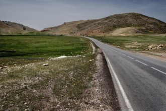 An asphalted road runs through the green and hilly countryside of Col Ouzad, Col Ouzad, Béni
