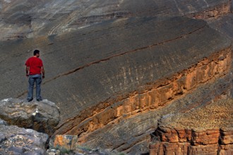 Man standing on rocks and looking at the impressive Dadès Gorge, Dadès, Morocco