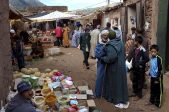 Lively market in Achaouikh with vendors and customers wearing colorful traditional clothes, zero